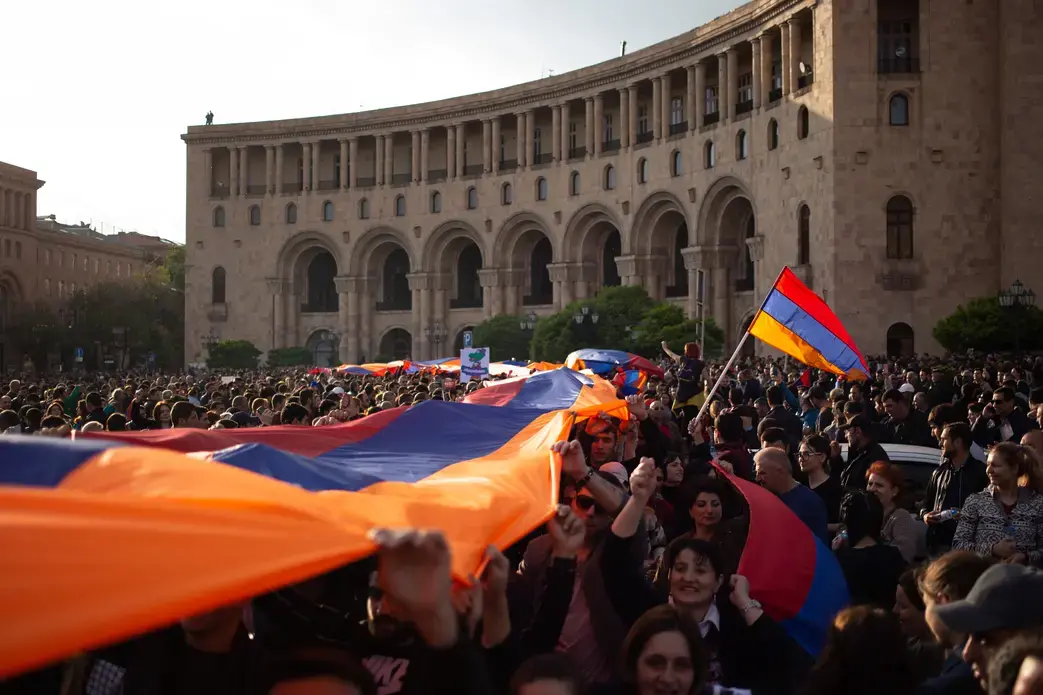 Protesters holding an Armenian flag on Yerevan's Republic Square during a rally in 2018. Image by Kacper Kawecki / Shutterstock. Armenia, 2018. Protesters holding an Armenian flag on Yerevan's Republic Square during a rally in 2018. Image by Kacper Kawecki / Shutterstock. Armenia, 2018.
