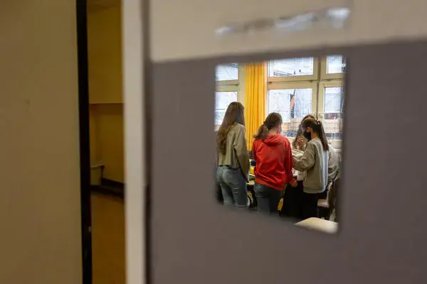 Students working on a book project at the Fritz-Karsen-Shule in Berlin are reflected in a mirror on the classroom wall. Image by Ryan Delaney. Germany, 2020. Students working on a book project at the Fritz-Karsen-Shule in Berlin are reflected in a mirror on the classroom wall. Image by Ryan Delaney. Germany, 2020.