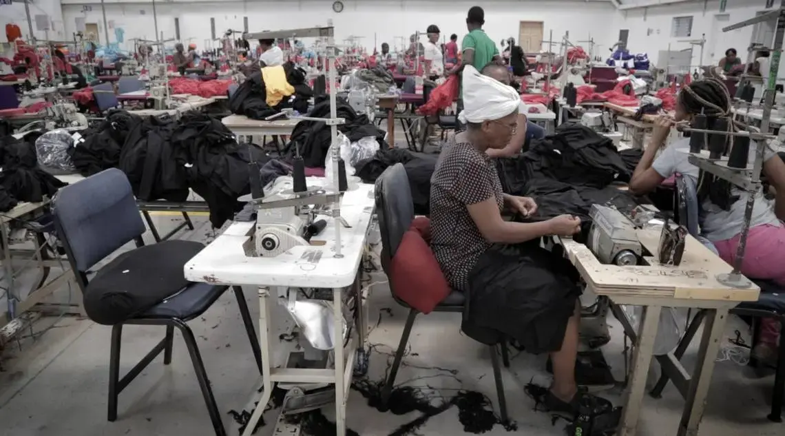 A female Haitian factory worker sews at Cleveland Manufacturing in Port-au-Prince, Haiti. The factory is among several working with two nonprofits to screen female workers for cervical cancer. Image by José A. Iglesias. Haiti, 2018. A female Haitian factory worker sews at Cleveland Manufacturing in Port-au-Prince, Haiti. The factory is among several working with two nonprofits to screen female workers for cervical cancer. Image by José A. Iglesias. Haiti, 2018.