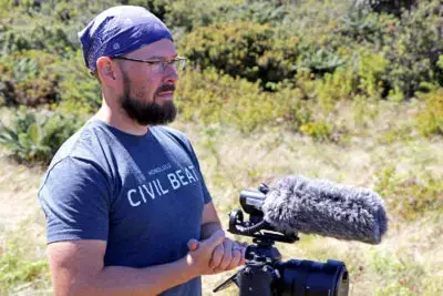 Civil Beat reporter Nathan Eagle preparing for an interview in Hanawai Natural Area Reserve while on assignment covering the endangered kiwikiu in October. Image by Dan Dennison. United States, 2019. Civil Beat reporter Nathan Eagle preparing for an interview in Hanawai Natural Area Reserve while on assignment covering the endangered kiwikiu in October. Image by Dan Dennison. United States, 2019.