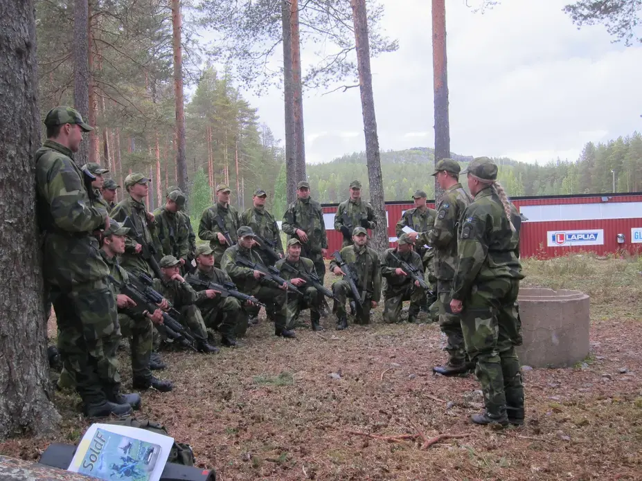 Female and male instructors debrief Swedish mechanized infantry recruits during training. In this platoon, 1 of 58 recruits is a woman. Image by Teresa Fazio. Sweden, 2018. Female and male instructors debrief Swedish mechanized infantry recruits during training. In this platoon, 1 of 58 recruits is a woman. Image by Teresa Fazio. Sweden, 2018.