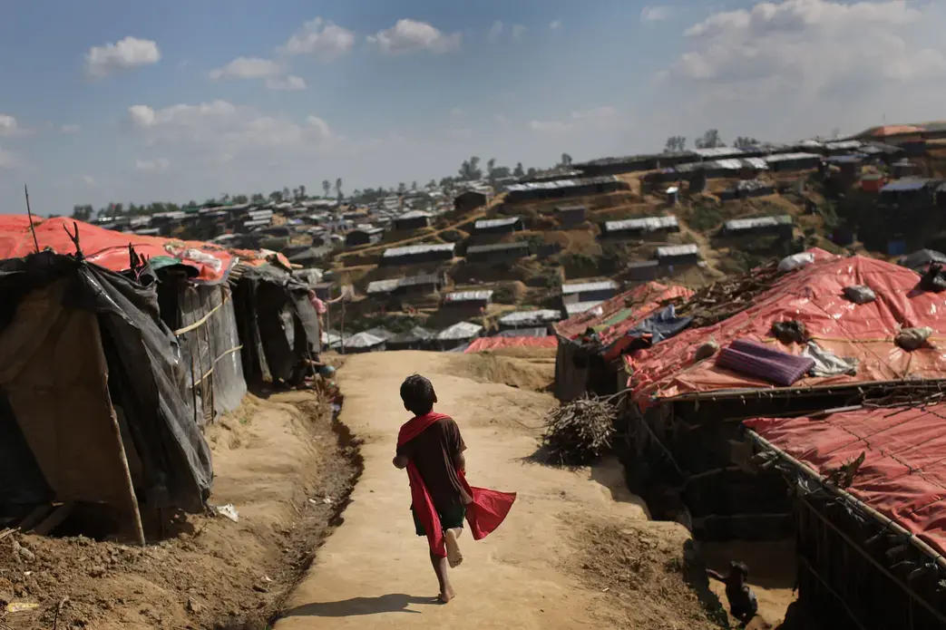 In this November 19 photo, a Rohingya Muslim child runs on a mud track between tents at Kutupalong refugee camp in Bangladesh. Image by Maye-e Wong. Bangladesh, 2017. 