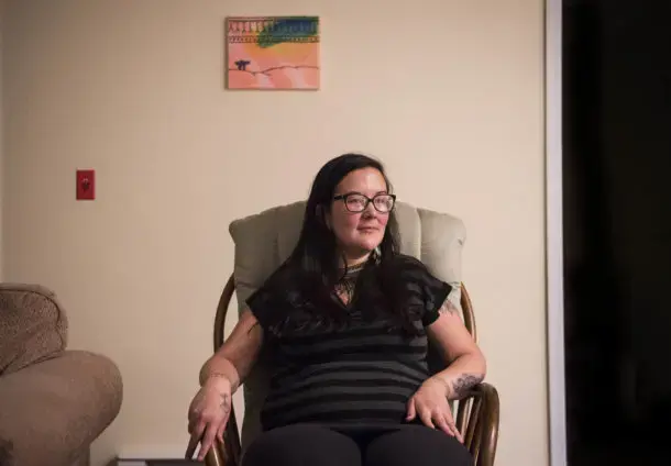 Erin Saunders, 35, at her apartment in the military base town of Happy Valley-Goose Bay, Labrador. Saunders was arrested protesting the construction of a local Canadian hydropower dam, which she says threatens her way of life. Image by Michael G. Seamans. Canada, 2019. Erin Saunders, 35, at her apartment in the military base town of Happy Valley-Goose Bay, Labrador. Saunders was arrested protesting the construction of a local Canadian hydropower dam, which she says threatens her way of life. Image by Michael G. Seamans. Canada, 2019.
