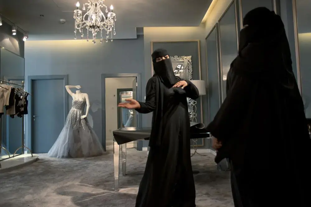 Two Saudi saleswomen in Harvey Nichols, the British luxury department store, in Riyadh. In 2011, the Ministry of Labor ordered shops specializing in cosmetics, abayas, and wedding dresses, along with the women’s sections of department stores, to begin shifting to all-female Saudi sales staffs. The process is called “feminization.” Image by Kate Brooks. Saudi Arabia, 2013. Media file: zoepf_saudiwomen0001-1.jpg