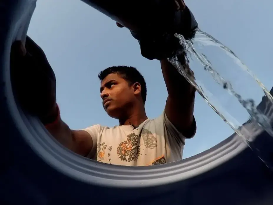 Mukindra Suryawanshi, 22, fills his family's water tank in Maharashtra state in western India. He and his relatives carry the tank on an ox cart and fill it up at another farmer's irrigation well. The water, drawn from about 850 feet underground, is used for washing, cooking and bathing by an extended family of 22 people. Image by Steve Elfers. India, 2015. Media file: 635805961435177558-india01.jpg
