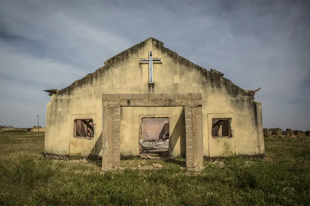 Barkin Ladi, Jos, Nigeria- The remains of a church in Garwaza Village in Barkin Ladi, Nigeria on Tuesday, October 23, 2018. Villagers were warned of the attack by Fulani members of their community before the attacked on June 23, 2018 by masked gunmen speaking in Hausa, leading many in the community to believe that they were Fulani. Most of the 2000 villagers fled to neighboring Tenti-Babba town where they remain displaced.Over one thousand people have lost their lives this year due to an ongoing conflict between farmers and herders. The current crisis reflects the country's woes from over-population, poverty and climate change to religious division and ethnic favoritism. Growing animosity between ethnic groups coupled with a lack of security has fomented this increase in violence in recent years. Despite the divisive chaos engulfing the Middle Belt of Nigeria, a group of multi-ethnic men and women, part of the Vigilante Group of Nigeria, are providing much needed security and trust to all groups affected by… Media file: hahn_wapo_nigeria_vigilantes_03-2.jpg