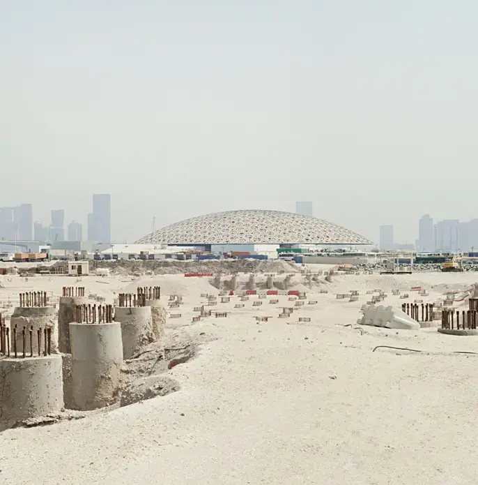 The Louvre Abu Dhabi dome and the site of the Guggenheim’s troubled project. Image by Knut Egil Wang. UAE, 2016.