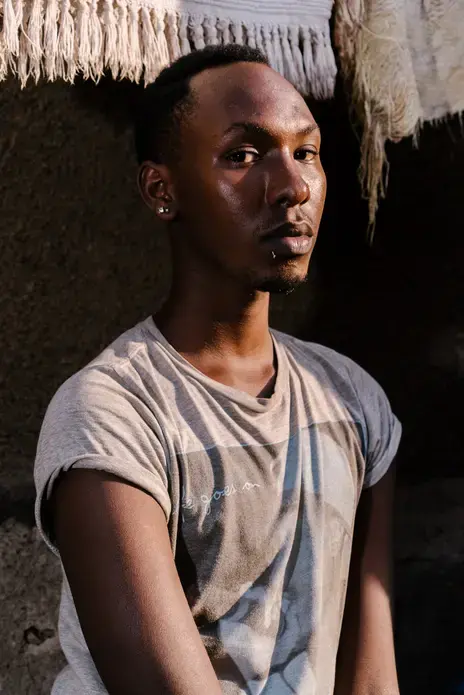 Javan, 19, a transgender woman, poses for a portrait near her mother's apartment in Kampala. She spent around eight months in Kenya as a refugee there after a mob beat her, stripped her naked and paraded her up and down the street yelling, "He's a homo," behind her near her Kampala home. Last summer, however, she returned to Uganda in order to make a stand. Image by Jake Naughton. Uganda, 2017. Javan, 19, a transgender woman, poses for a portrait near her mother's apartment in Kampala. She spent around eight months in Kenya as a refugee there after a mob beat her, stripped her naked and paraded her up and down the street yelling, "He's a homo," behind her near her Kampala home. Last summer, however, she returned to Uganda in order to make a stand. Image by Jake Naughton. Uganda, 2017.