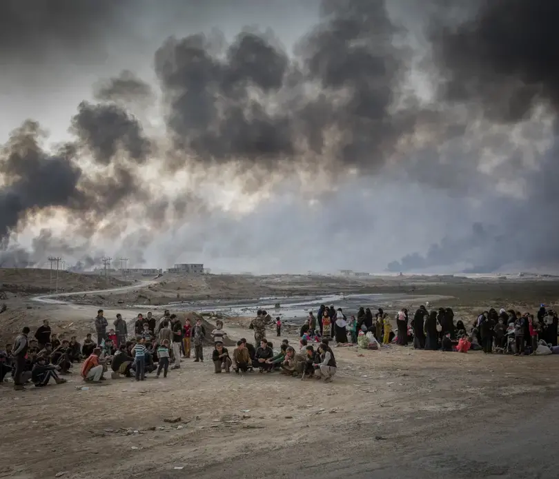 Internally displaced people fleeing from fighting in the village of Shora, 25km south of Mosul, reach an Iraqi army checkpoint on the Northern outskirts of Qayyarah. Image by Ivor Prickett/UNHCR/Panos. Iraq, 2018. Internally displaced people fleeing from fighting in the village of Shora, 25km south of Mosul, reach an Iraqi army checkpoint on the Northern outskirts of Qayyarah. Image by Ivor Prickett/UNHCR/Panos. Iraq, 2018.