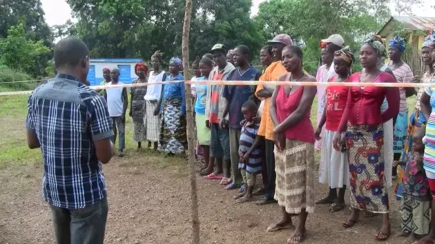 Father Francis Sehdu Sesay talks to the quarantined villagers of Tambiama. Image by Erika Check Hayden. Sierra Leone, 2014. Media file: img_0117.jpg