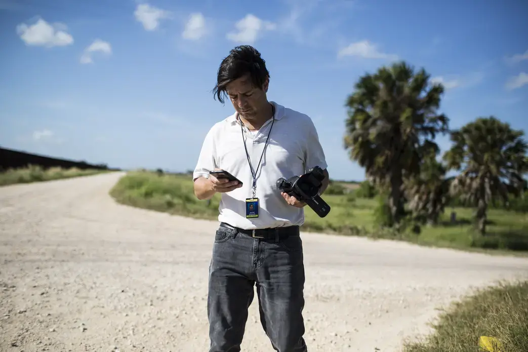 Julián Aguilar reporting near the border fence in Cameron County, Texas. Image by Martin do Nascimento. United States, 2017. Julián Aguilar reporting near the border fence in Cameron County, Texas. Image by Martin do Nascimento. United States, 2017.