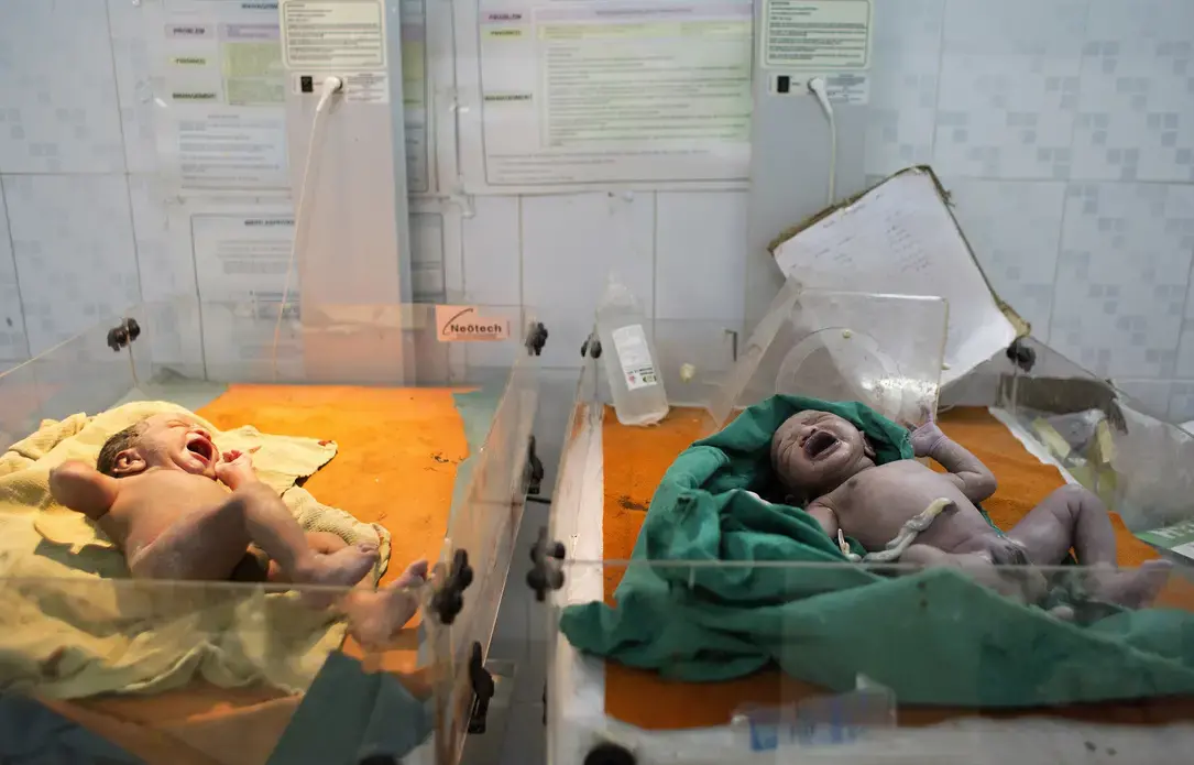 Two babies, shortly after being born by caesarean delivery, at Medavakkam Primary Health Centre, a government-run public hospital outside Chennai. Image by Sarah Weiser. India, 2014. Media file: sw_pulitzer_babyshot.jpg