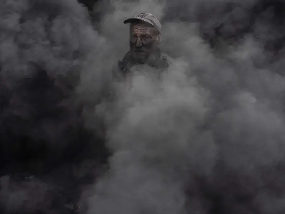A worker at an outdoor quicklime kiln in the southeastern village of Kosturino, Macedonia. The operation — just one of dozens of prominent sources of air pollution in the country — burns tires for fuel. Image by Larry C. Price. Macedonia, 2018. A worker at an outdoor quicklime kiln in the southeastern village of Kosturino, Macedonia. The operation — just one of dozens of prominent sources of air pollution in the country — burns tires for fuel. Image by Larry C. Price. Macedonia, 2018.
