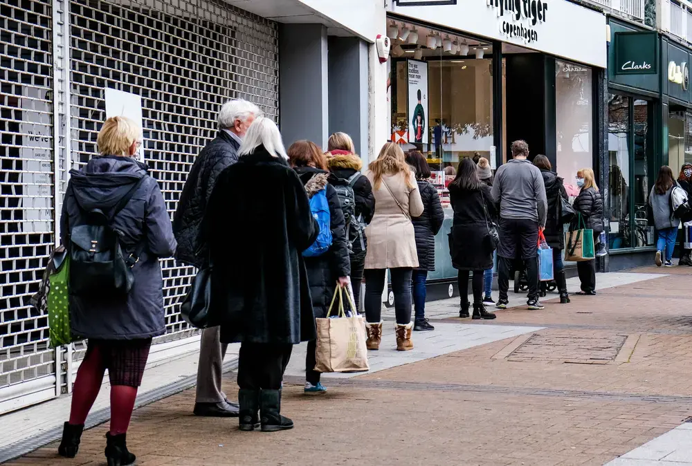 A line of people queuing to enter a shop on December 9 during COVID-19 Tier 2 restrictions in Kingston, London. Image by Richard M Lee / Shutterstock. United Kingdom, 2020. A line of people queuing to enter a shop on December 9 during COVID-19 Tier 2 restrictions in Kingston, London. Image by Richard M Lee / Shutterstock. United Kingdom, 2020.
