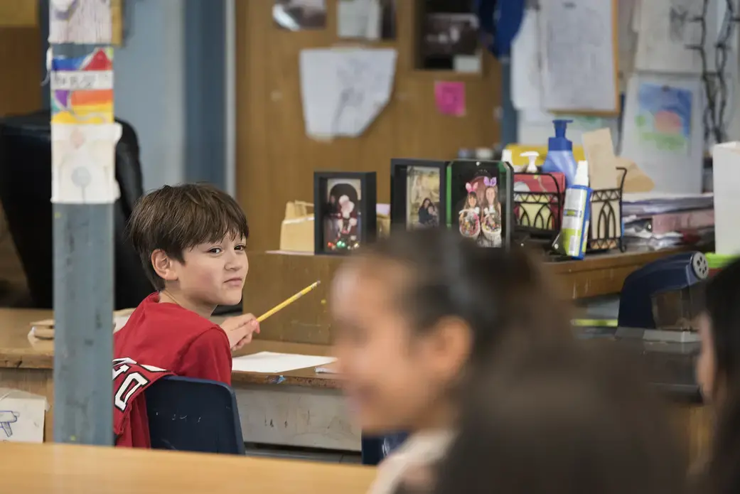 Edward Flores turns to chat with classmates while learning about the color wheel in his middle school art class Dec. 2. Image by Amanda Cowan. United States, 2019.