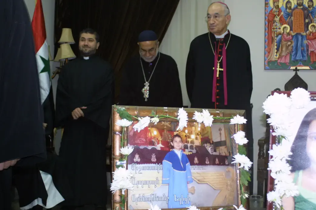 Three Christian priests at a funeral for Christian children killed by rebel mortar fire. Image by Reese Erlich. Syria, 2013. Media file: 3_clerics_standing.jpg