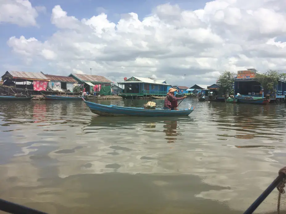 An ethnic Vientamese food vendor paddles through a floating village on Tonlé Sap Lake. Image by Ben Mauk. Cambodia, 2017.
