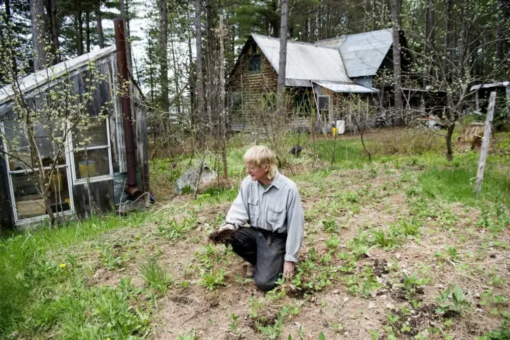 Duane Hanson checks the soil of his garden as prepares for the new growing season at his homestead in the Unorganized Territories in the north woods of Maine near T5 R7 on May 27, 2019. Image by Michael G. Seamans. United States, 2019.