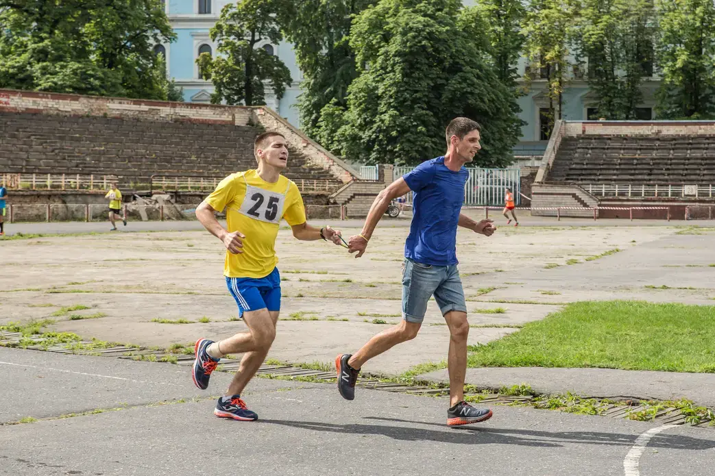 Oleksandr Popruzhenko (yellow) runs with teammate Oleksandr Radioniuk (blue) in the qualifying race for the marathon. Image by Oksana Parafeniuk, courtesy of Roads & Kingdoms. Ukraine, 2018.