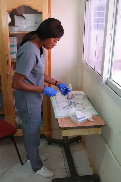 A nurse at the IHI offices prepares instuments for a breast biopsy. Image by Kate Corrigan. Haiti, 2017. 