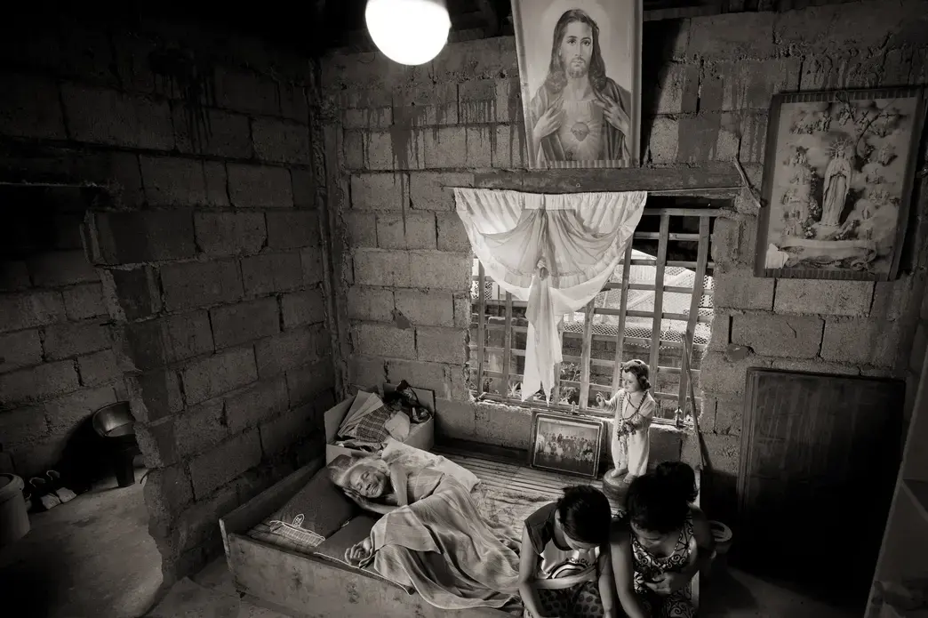 Juliana dela Cruz, 92, lies at her home in Roxas City on May 27, 2019. She died Sept. 12 of that year. In 1998, she testified: 'At the garrison, they imprisoned me in a room. The cook was the only one who could give me food. The only other ones I saw were the three soldiers who came into my room every night and raped me three to five times a night in the course of one month.' Image by Cheryl Diaz Meyer. Philippines, 2019.