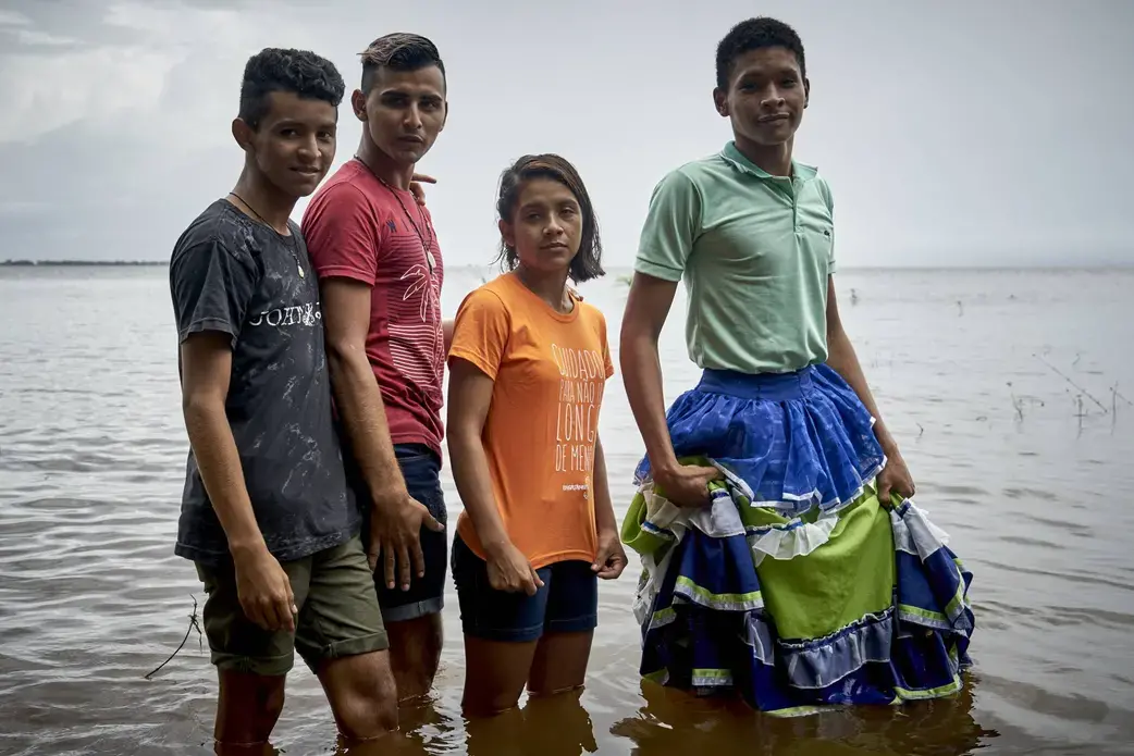 Dani and her friends on the banks of the Tapajós River standing in support of of LGBTQ+ rights. Image by Pablo Albarenga. Brazil, 2019.
