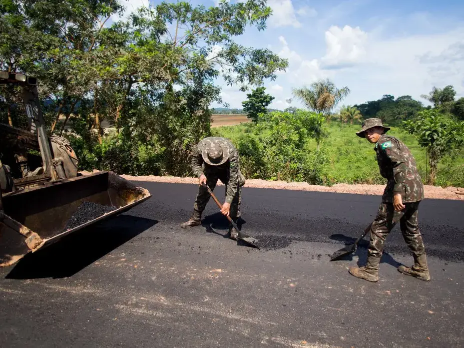 Soldiers pave some of the last miles of BR-163, a highway cutting through the Amazon basin which Bolsonaro had pledged to complete. For years, trucks carrying grain for export have lumbered along this slow, muddy road. Its completion significantly reduces transport time. Image by Heriberto Araújo. Brazil, 2019.