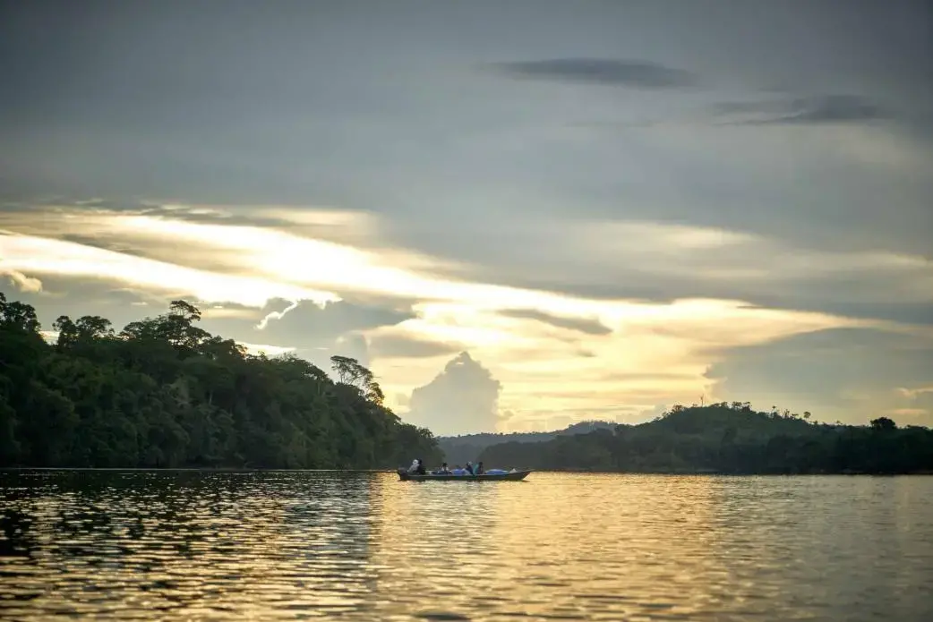 A boat sails over the Arinos River. Image by Pablo Albarenga. Brazil, 2018.