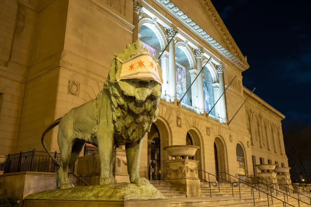 A lion statue outside the Art Institute of Chicago wears a mask. Image by Bret Habura/Shutterstock. United States, 2020. A lion statue outside the Art Institute of Chicago wears a mask. Image by Bret Habura / Shutterstock. United States, 2020.