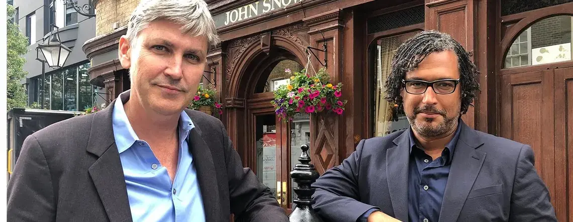 Steven Johnson and David Olusoga stand together on a city street.
