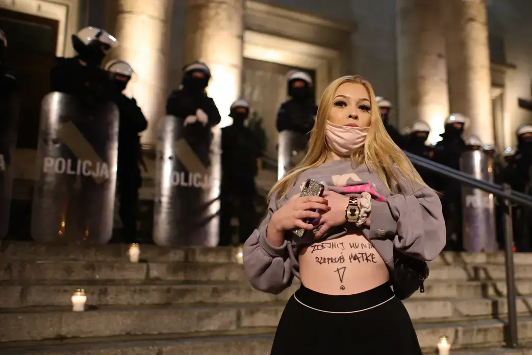 A person exposes their stomach in front of law enforcement during an abortion rights demonstration in Poland.