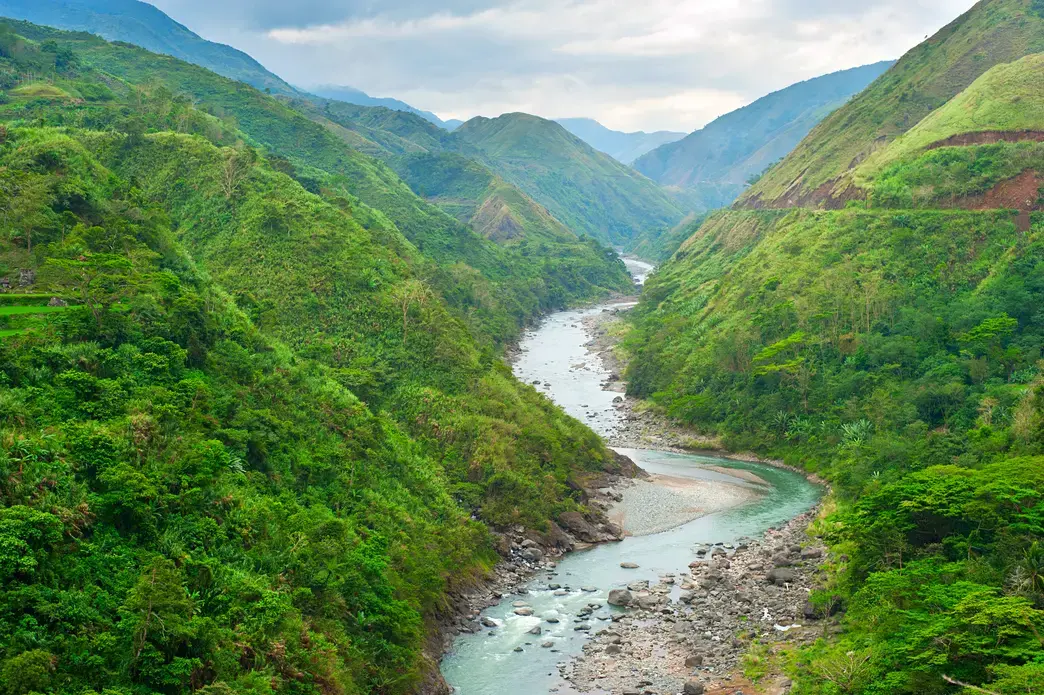 shutterstock_121740229.jpeg A river runs through green mountains.