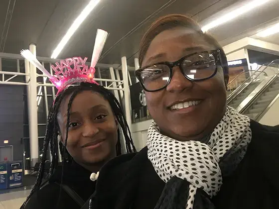 A photo of Saichelle McNeill and her daughter J’Nai. J'Nai wears a "Happy New Year" headband.