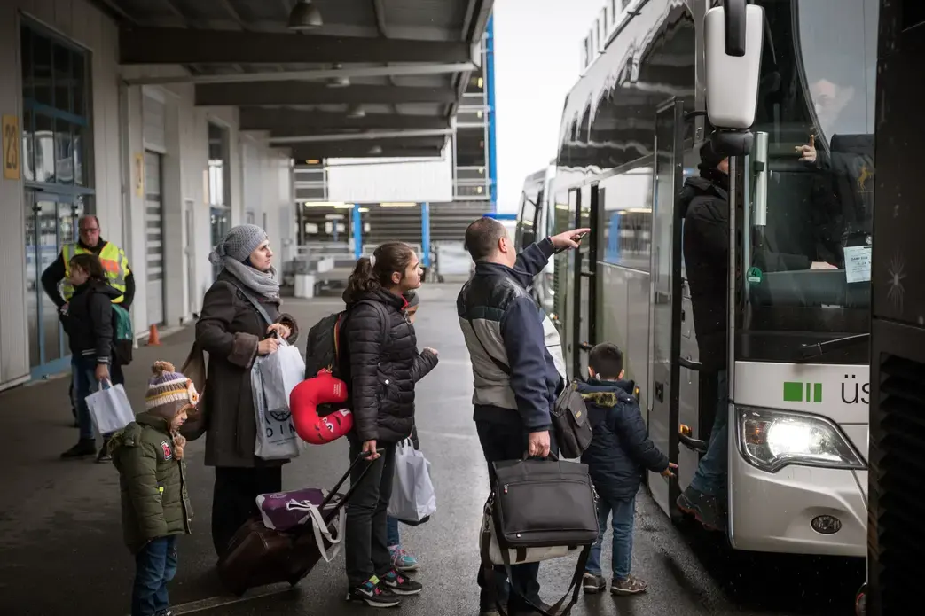 Syrian refugees at Hanover airport boarding a bus to Friedland, Germany.