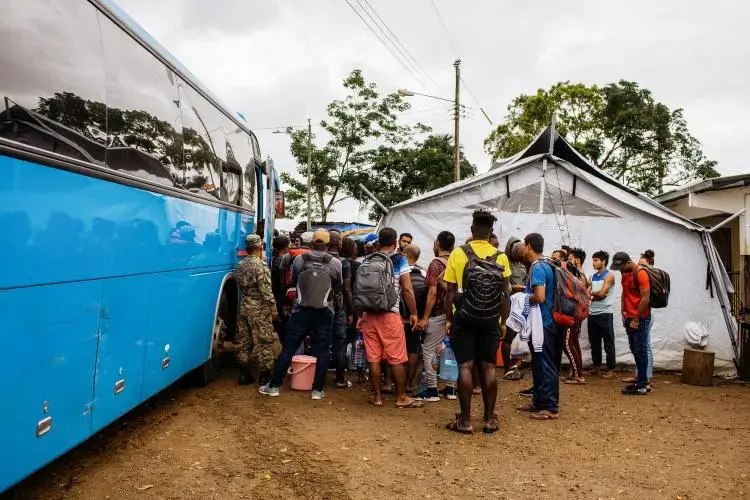 Migrants and refugees board bus