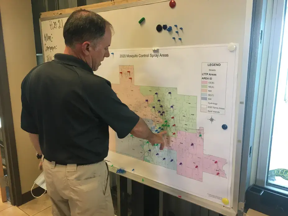IMG_6849.JPG Scott Harrington, Calcasieu Parish Mosquito Control manager, in front of map