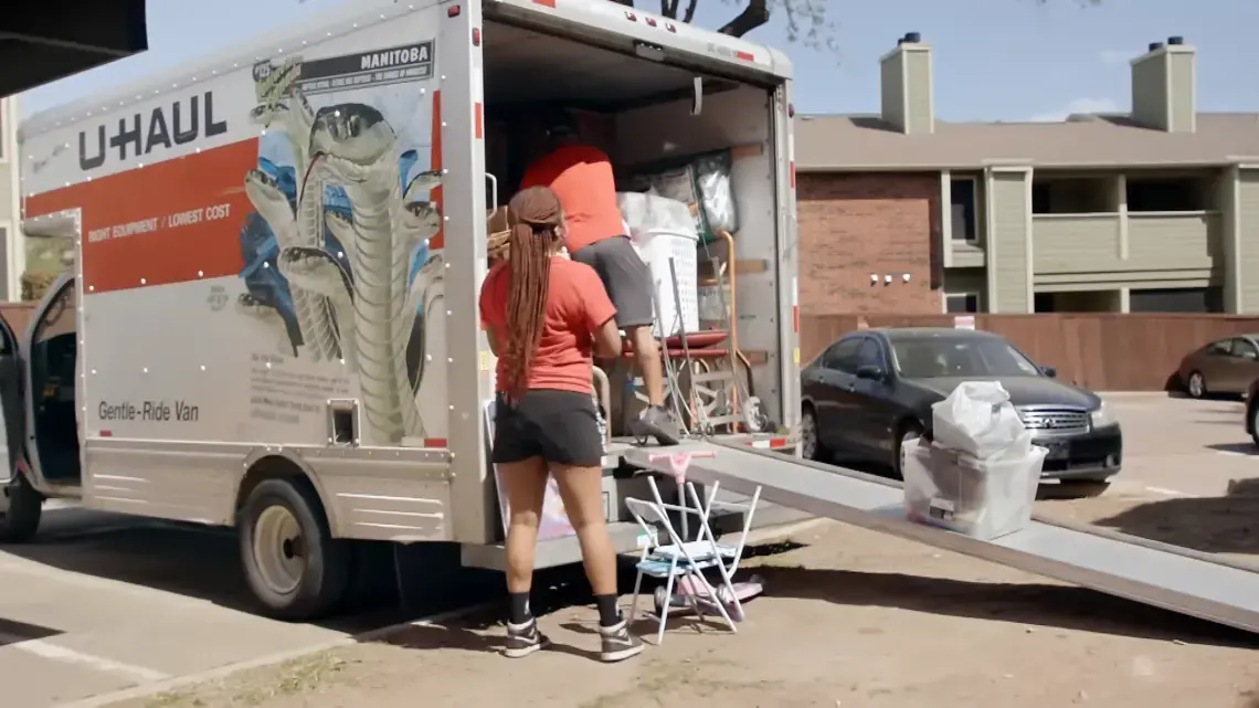 A woman loads a UHAUL truck.