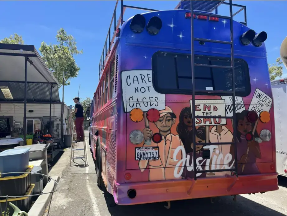 Care not Cages Picketers, speaking out against solitary confinement, painted on a retro-fitted schoolbus.