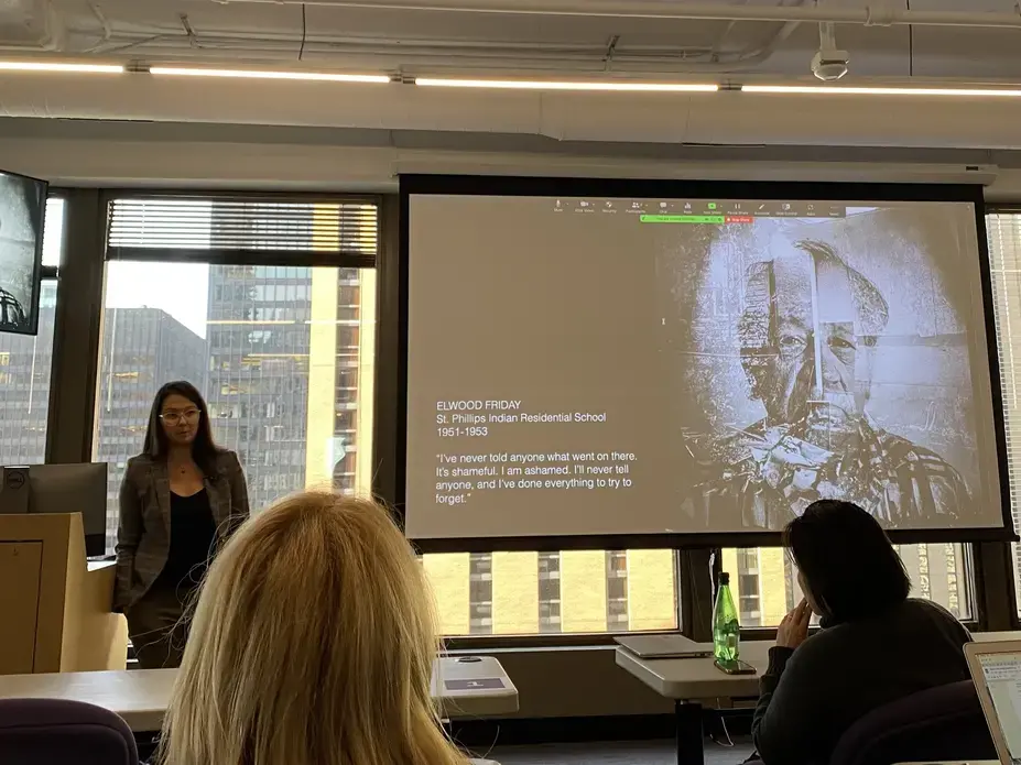 Zalcman.jpg Zalcman stands next to presentation screen with work on Indigenous communities.