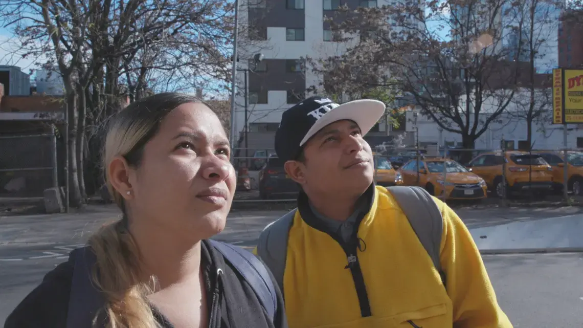 Jeczebel Lopez and Jorge Ojeda stand in front of their shelter in New York. Image by Mayara Teixeira. United States, 2022.