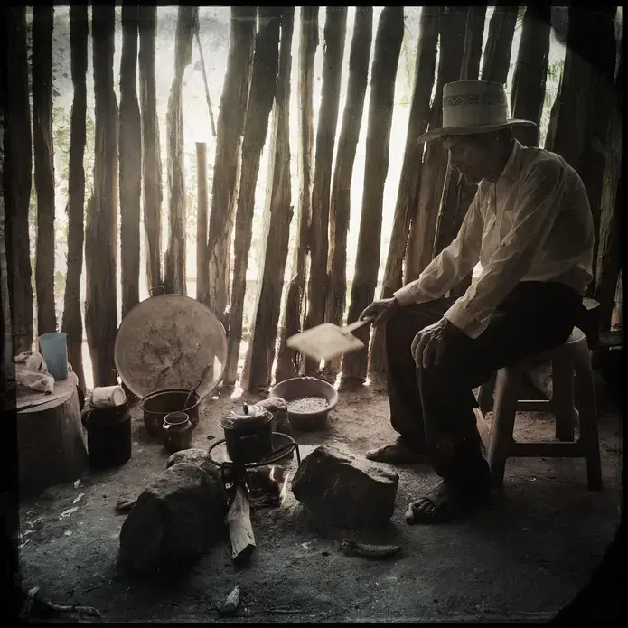 San Ramon: In a small town in southern Guatemala, an elderly man cooks over an open fire. He and his neighbors recently moved here from the Rio Squisal Valley, near the border with Mexico, in search of better farmland. Image by Lynn Johnson. Guatemala, 2017.