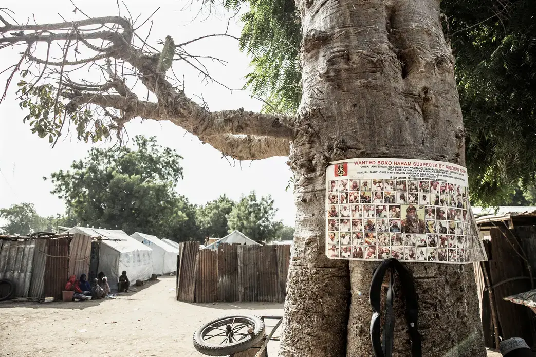A sign at a refugee camp in northern Nigeria showing people wanted on suspicion of being Boko Haram members. Image by Glenna Gordon. Nigeria, 2017.