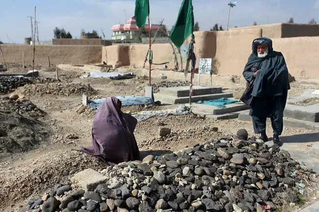 Zarmina's parents at her grave. A poet, she died after setting herself on fire. Image by Seamus Murphy/VII. Afghanistan, 2012. Media file: 29poets3-popup.jpg