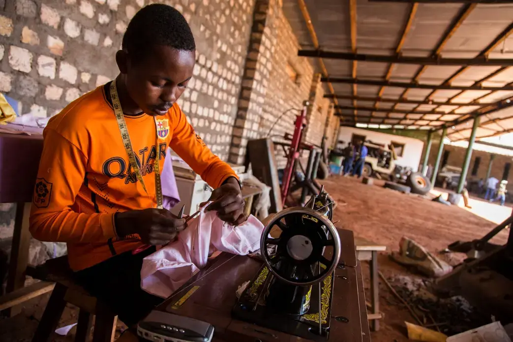 Lebron Baroka, an 18-year-old from a militia-controlled town called Bangassou, works as a tailor at Chinko. Image by Jack Losh. Central African Republic, 2018.
