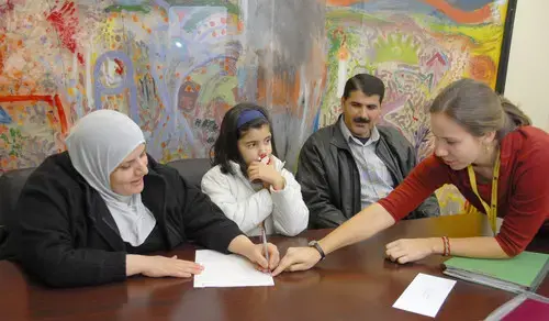 From left, Jenan, Zahra and Issam, who came to Baltimore in August, work with Sara Bedford, their case manager at the International Rescue Committee, in a follow-up meeting over employment. (Baltimore Sun photo by Chiaki Kawajiri / December 23, 2008) 1