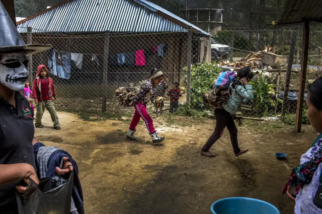 When men leave to find work in the United States, their tasks at home, like carrying wood, are left to wives and children, like these in Bulej, Guatemala. Image by Simone Dalmasso / For the Arizona Daily Star. Guatemala, 2019.