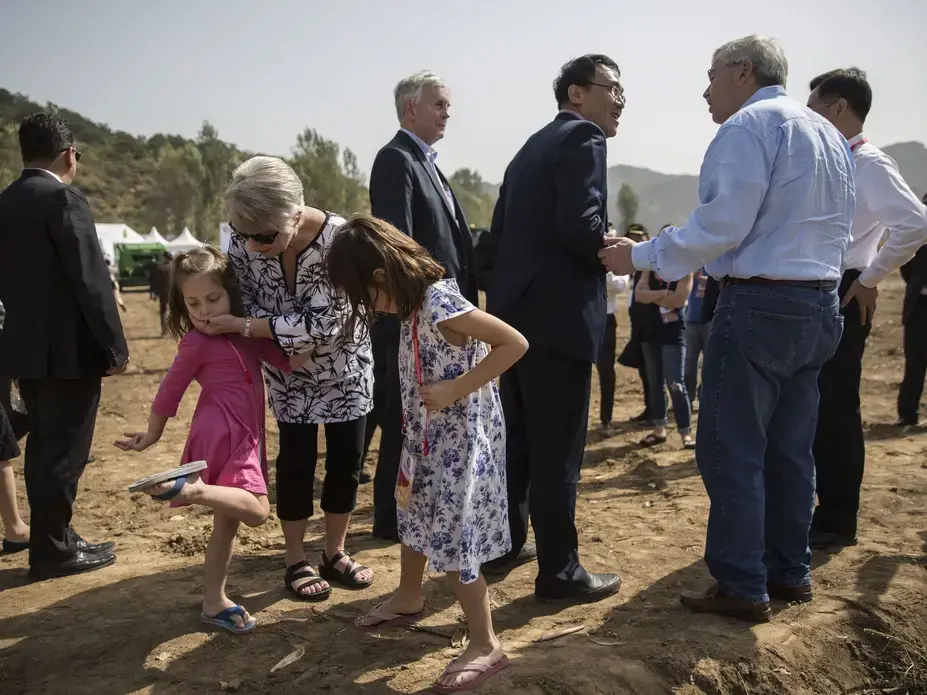 Chris Branstad, wife of U.S. Ambassador to China Terry Branstad, talks with her granddaughters Stella and Sofia Costa while attending the groundbreaking ceremony of the China-U.S. Demonstration Farm on Saturday, Sept. 23, 2017, in Luanping County, Hebei, China. Image by Kelsey Kremer. China, 2017.