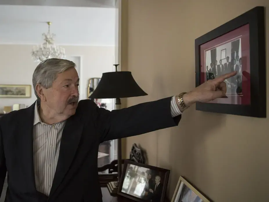 U.S. Ambassador to China Terry Branstad points to a photo taken during a 1985 visit to the Iowa State Capitol by Xi Jinping, China's current president. The photograph hangs inside the entry of his residence Sunday, September 24, 2017, in Beijing, China. Image by Kelsey Kremer. China, 2017.