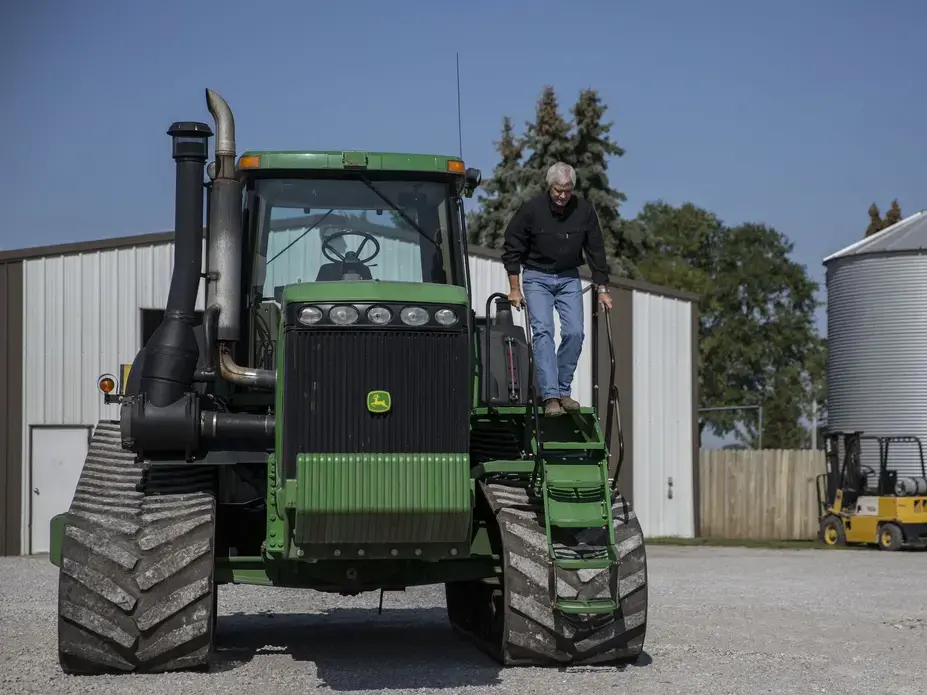 Rick Kimberley, a fifth generation family farmer from rural Maxwell, climbs down from the cab of one of his tractors on Tuesday, Sept. 5, 2017, on his farm in Polk County. The tractor has become well known by Chinese tourists because of a widely circulated photo of the President of China, Xi Jingping sitting in the tractor during his visit to the farm in 2012. Image by Kelsey Kremer. 