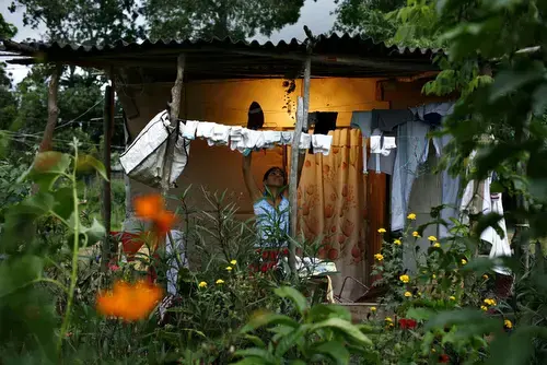 Nov. 15, 2006-- A woman folds clean laundry outside a squatter shack in the rural town of Montleban where dozens of families are protesting on private land in a demand for government housing assistance. 1
